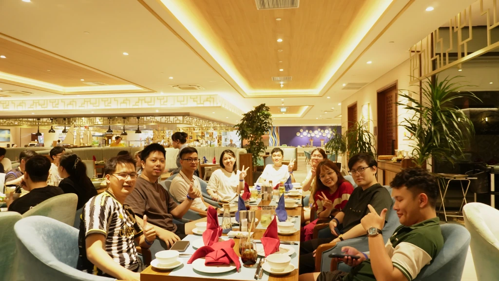 Team seated together in a restaurant, smiling for a casual outing picture