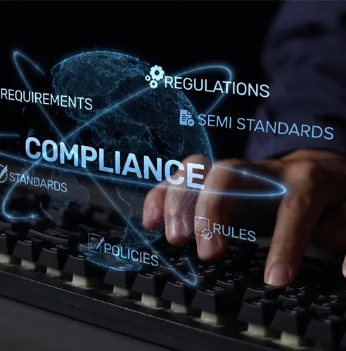 Close-up of hands typing on a keyboard with glowing words like Compliance, Regulations, Standards floating above.