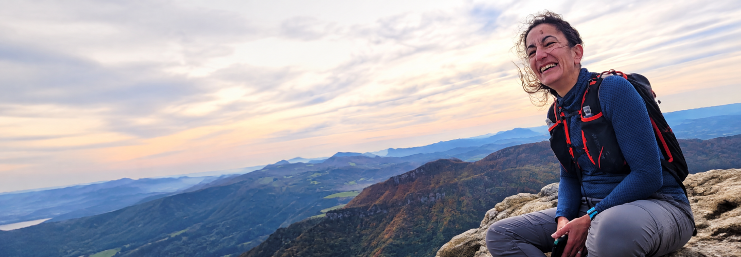 Smiling hiker enjoying a scenic mountain view.